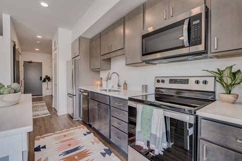 A modern kitchen with a stove top oven and microwave above it.