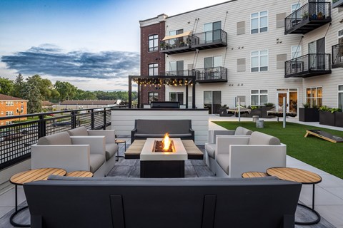A modern outdoor seating area with a fire pit in the center.