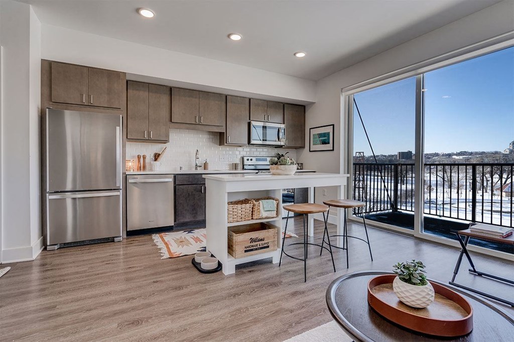 a kitchen with a island and a stainless steel refrigerator