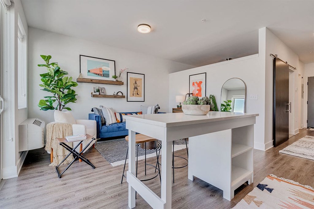 an open kitchen and living room with a white counter top