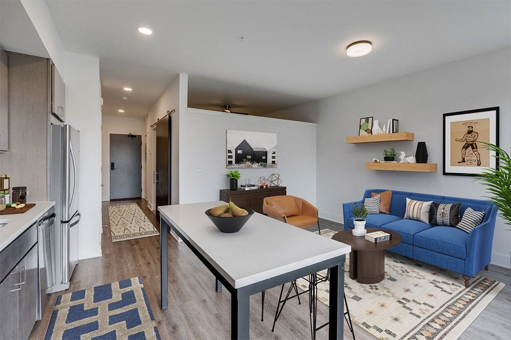 a living room and dining room with a blue couch and a table