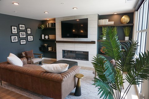 A living room with a brown couch and a fireplace.