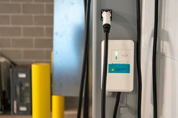 An electric vehicle charging station with a green light on.