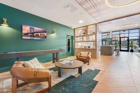 A modern living room with a green accent wall and a large painting of a bridge.