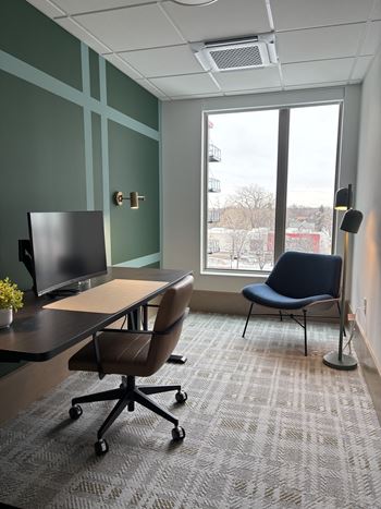 A room with a desk, chair, and a window.