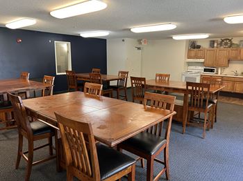 A large wooden table surrounded by chairs in a room.