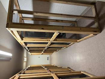 A room with wooden beams on the ceiling and a metal grid.