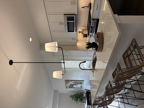 A white kitchen with a black ceiling light.