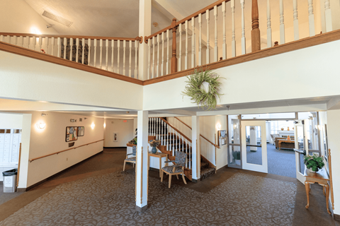 A large open living room with a staircase and a dining area.