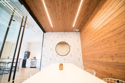 A bedroom with a bed in the foreground and a wooden wall in the background.