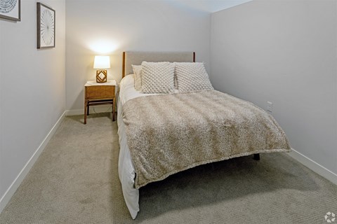 a bedroom with a bed and a night stand
