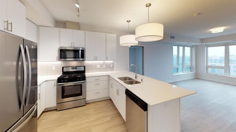 a white kitchen with stainless steel appliances and white counter tops