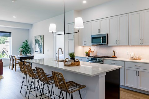A modern kitchen with white cabinets and a large island.