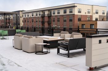 A patio with a black railing and furniture including a table and chairs.