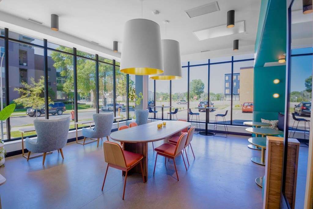 A room with a table and chairs with a view of the outside.