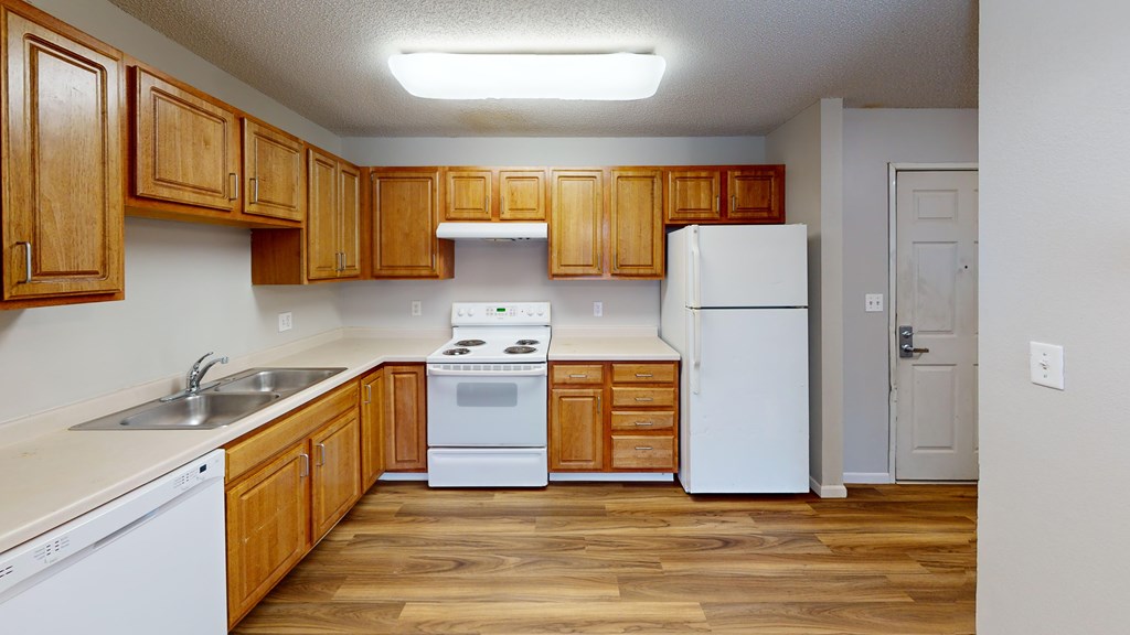 A kitchen with wooden cabinets and white appliances.