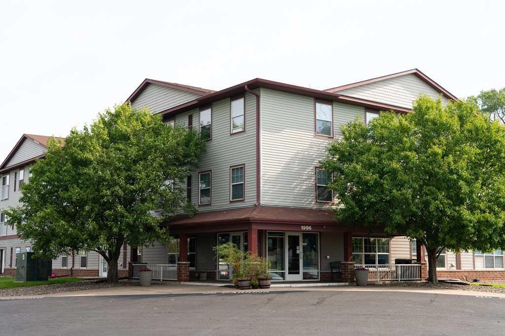 A two-story apartment building with a parking lot in front.