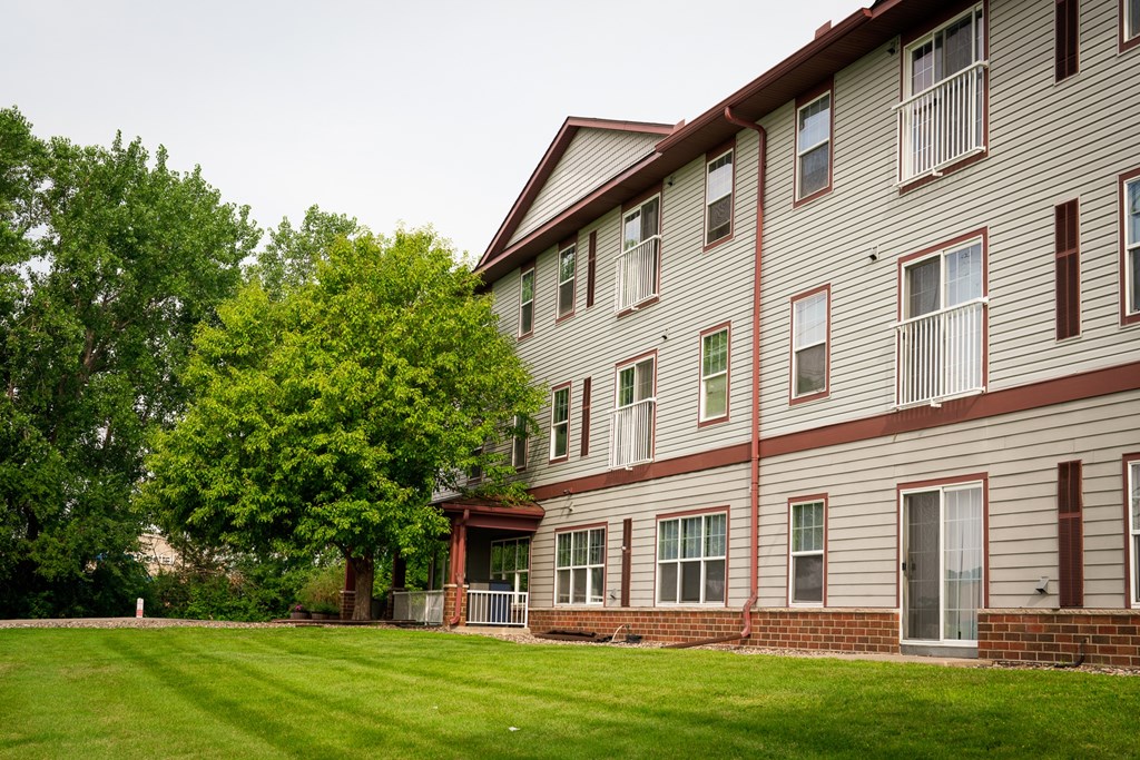 A large building with a green lawn in front.