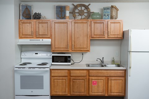 A kitchen with wooden cabinets and a white refrigerator.