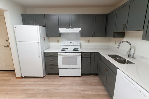A kitchen with a white refrigerator and a white stove top oven.
