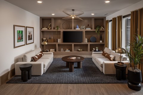 A modern living room with a white sofa, a coffee table, and a television on a wooden entertainment center.