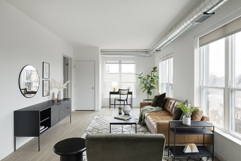 a living room with white walls and a brown leather couch