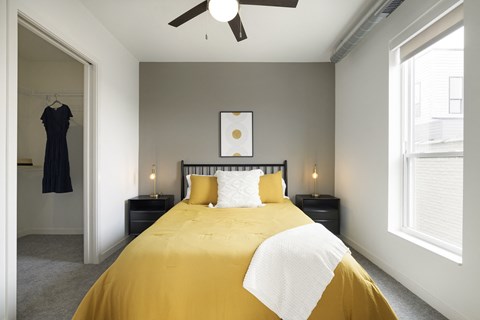 a bedroom with a large yellow bed and two windows
