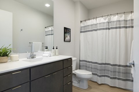 a bathroom with a toilet sink and shower in a 555 waverly unit