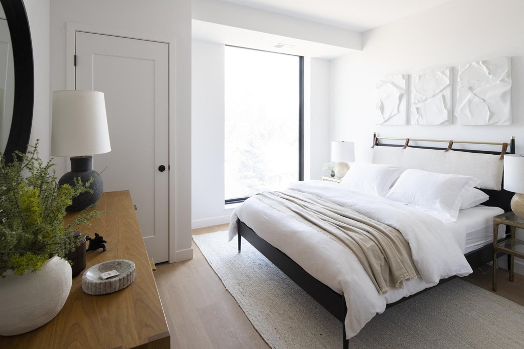 a bedroom with a bed and a dresser with a vase on it