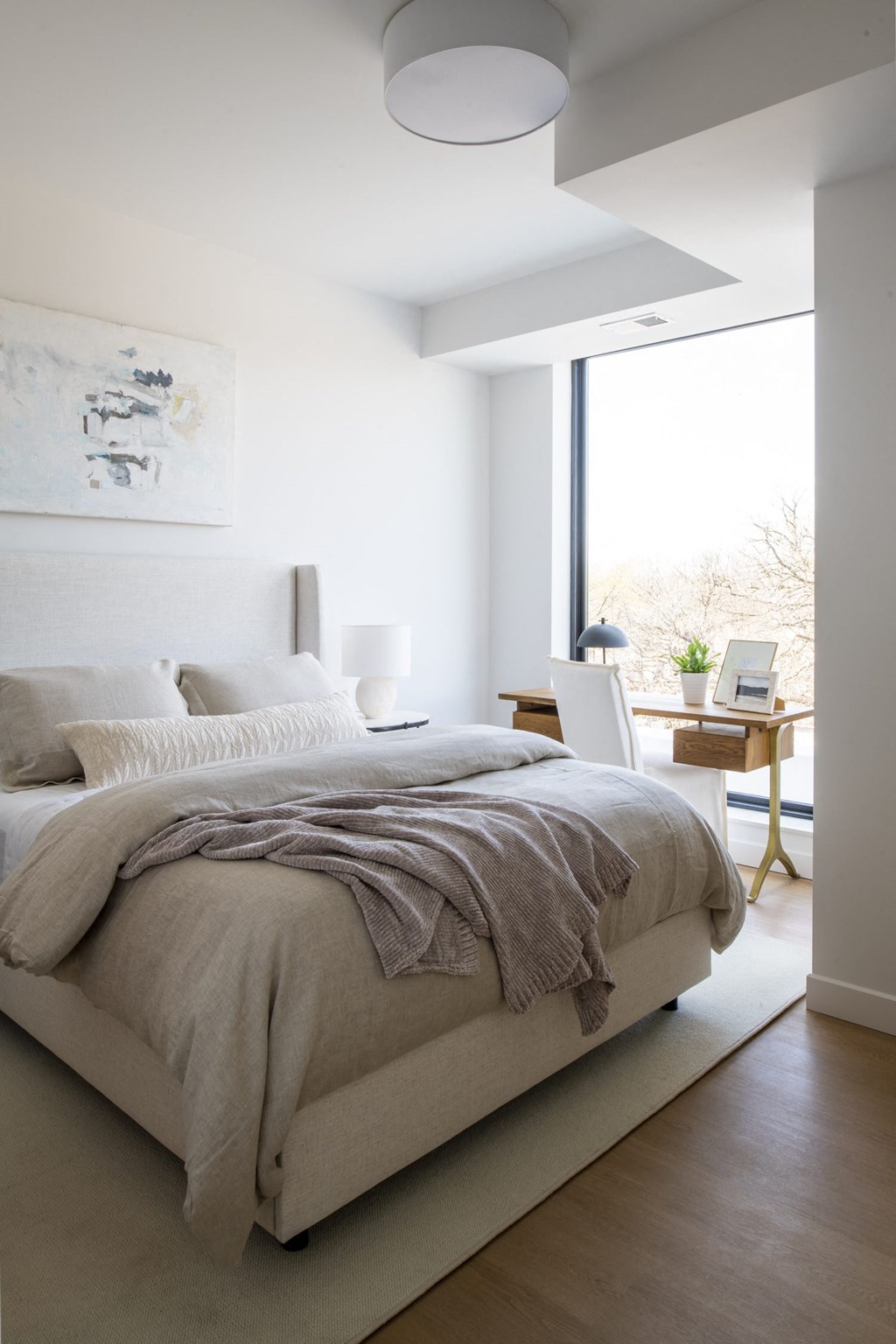 a bedroom with a bed and a desk with a laptop