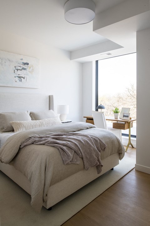 a bedroom with a bed and a desk with a laptop