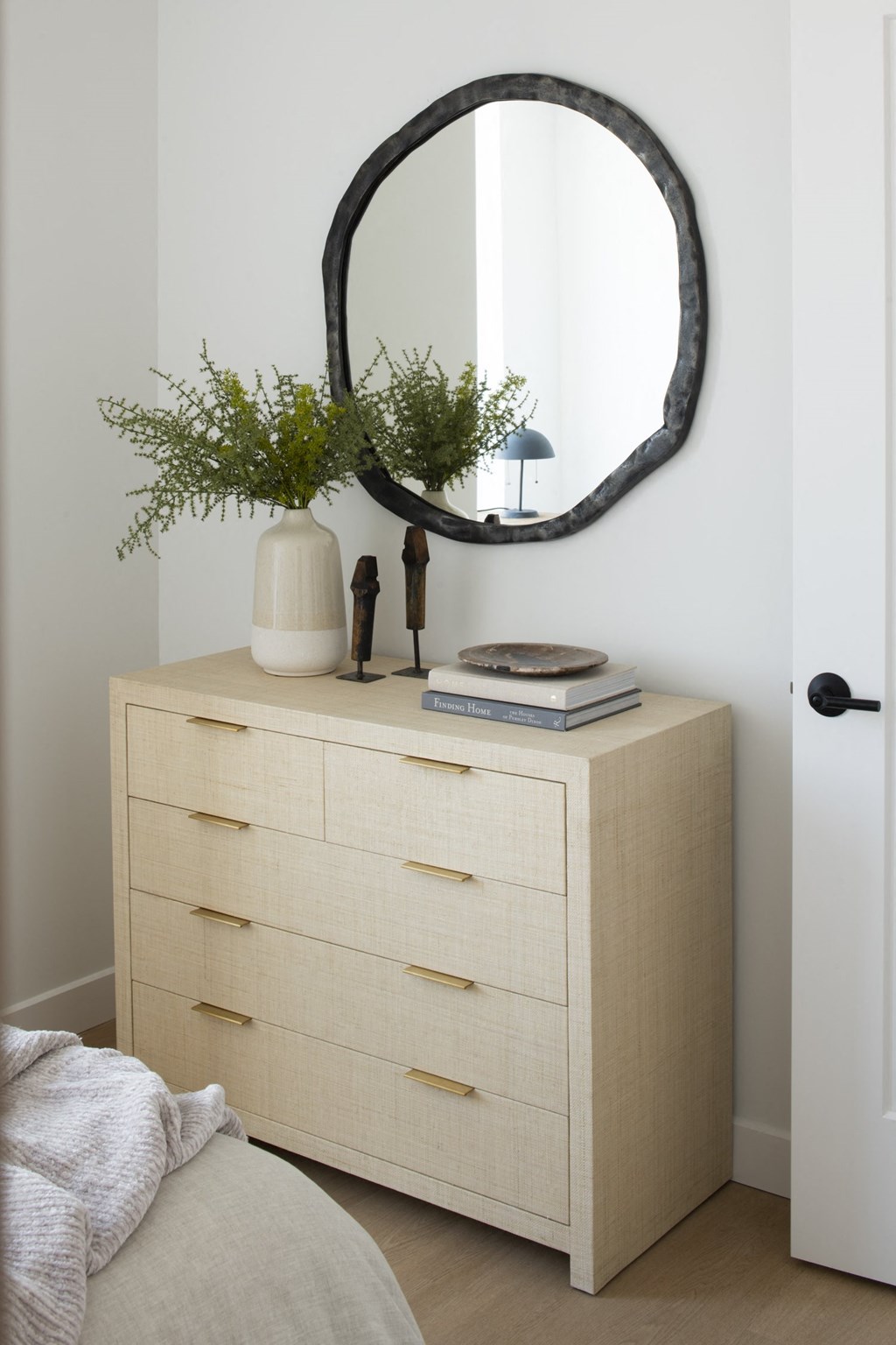a bedroom with a dresser and mirror