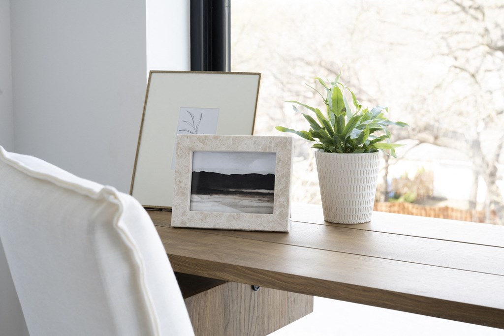 a picture frame on a table next to a plant and a picture