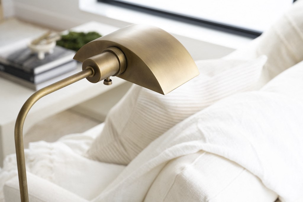 a bedside lamp with a white bedspread and white pillows