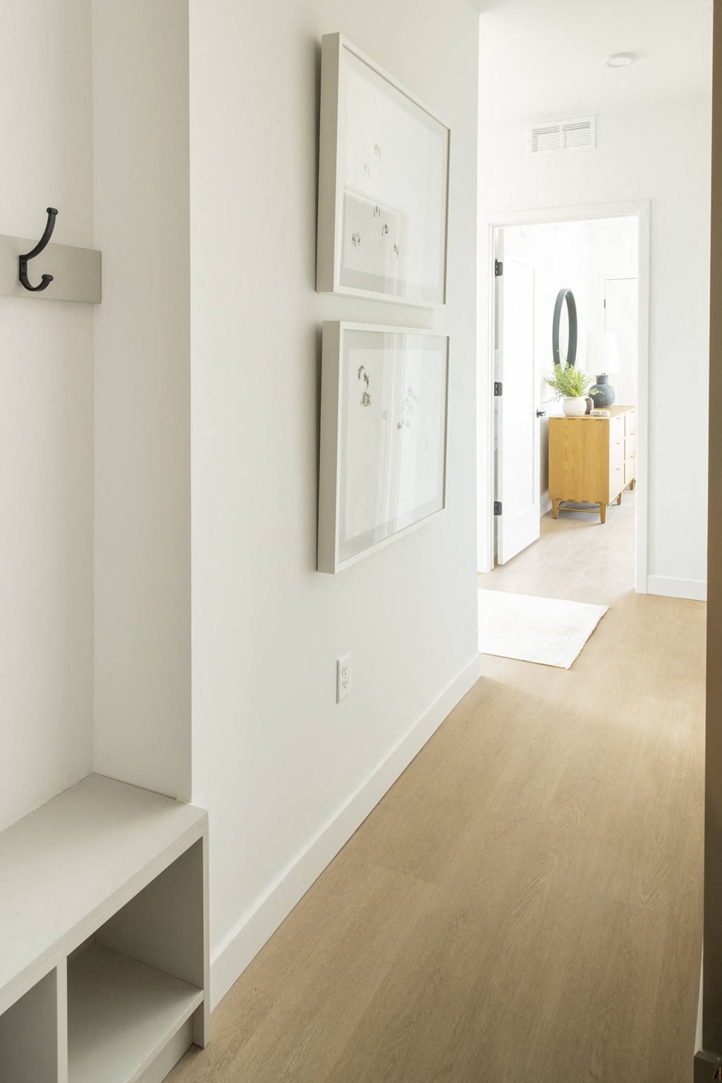 a bedroom with a medium hardwood floor and white walls