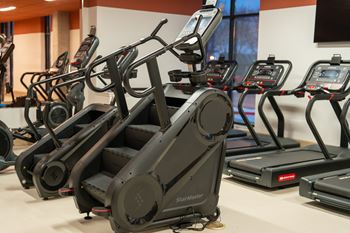 A StairMaster treadmill is in a gym with other treadmills.
