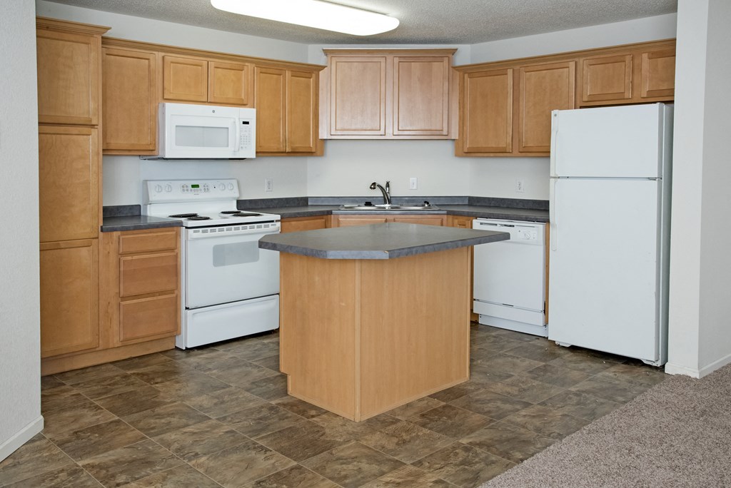 a kitchen with white appliances and wooden cabinets