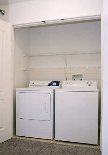 a washer and dryer in a room with a white wall and a door