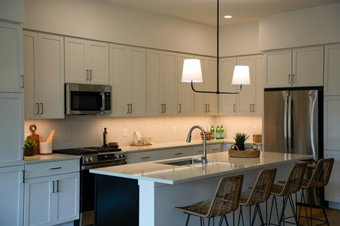 A kitchen with white cabinets and a black stove top oven.