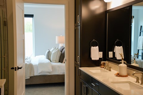 A bathroom with a bedroom view through the door.