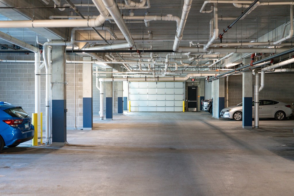 A parking garage with a blue car parked on the left side.