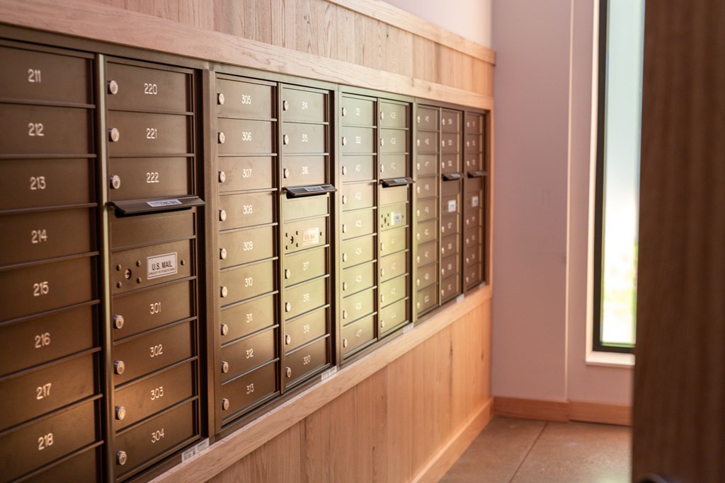 A row of mailboxes are lined up on a wall.