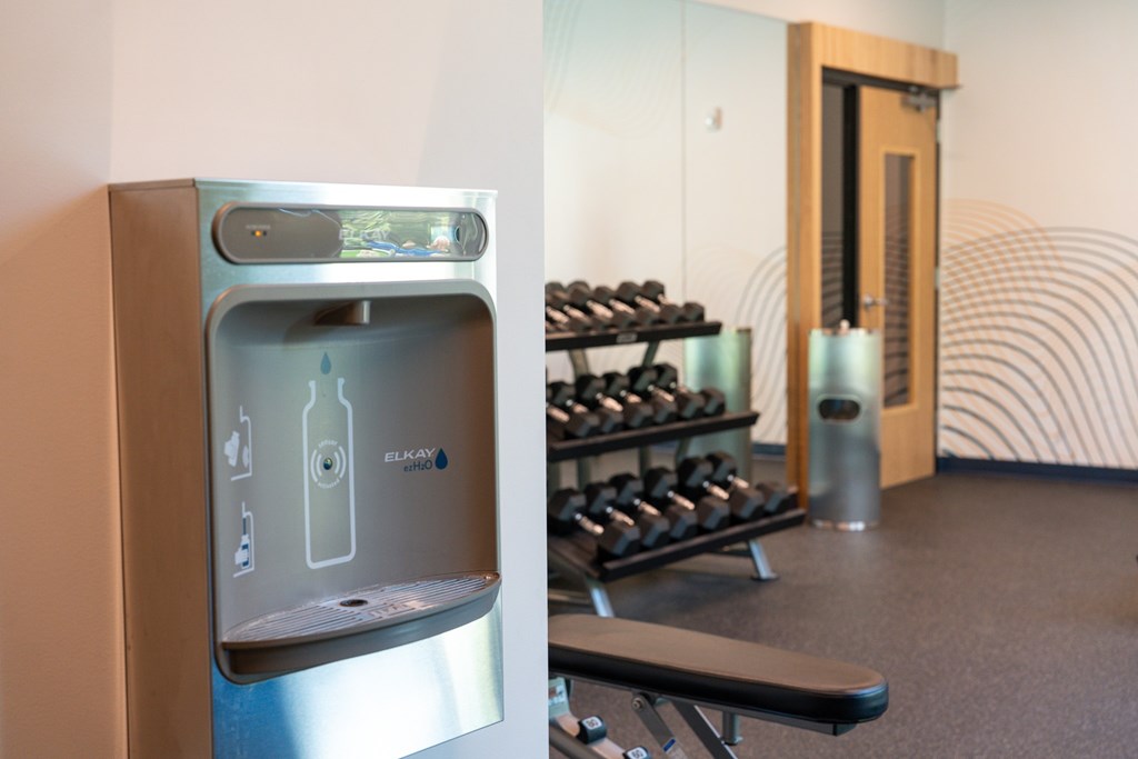A water fountain with a bottle on top of it.