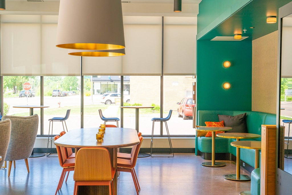 A restaurant with a table and chairs in front of a window with a view of the street.