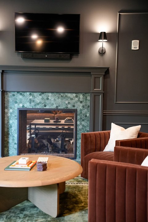 A living room with a fireplace and a flat screen TV mounted above it.
