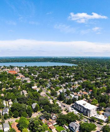 A bird's eye view of a residential area with a lake in the distance.