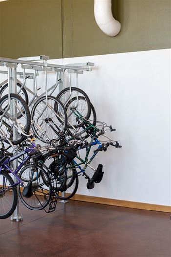 A bike rack with several bikes hanging on it.