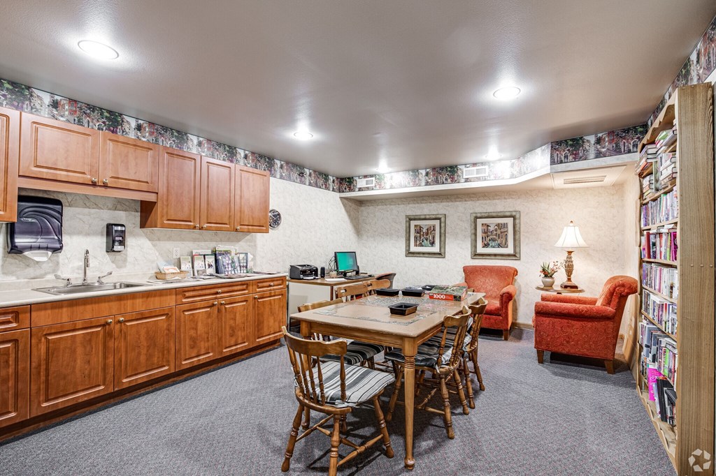 A kitchen with a dining table and chairs.