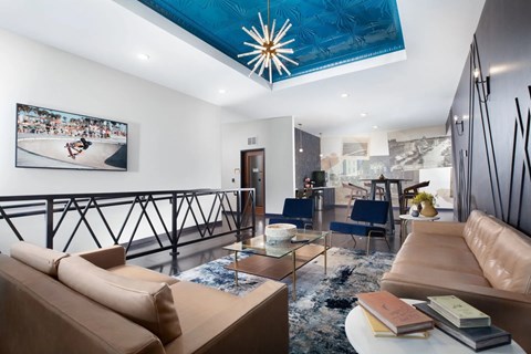 A living room with a tan sofa and a blue ceiling light.