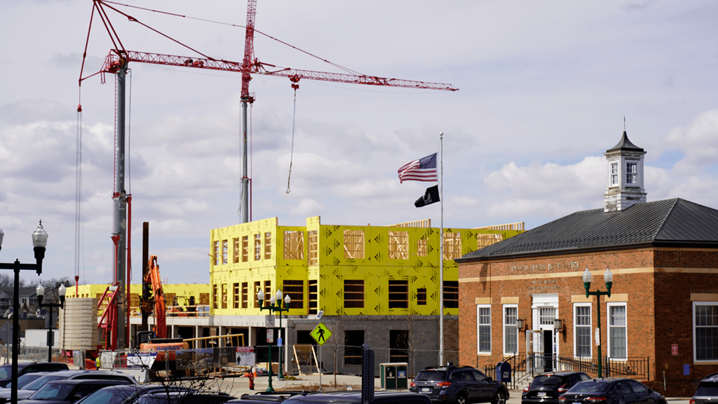 a large yellow building under construction in front of a crane